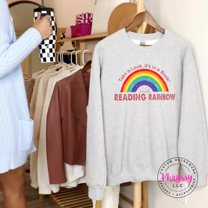 Ash gray reading teacher crewneck with a retro rainbow book design.