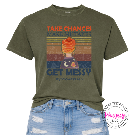 Teacher in a sage tee with retro Take Chances Get Messy design.