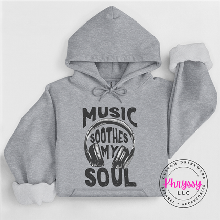 Gray hoodie with 'Music Soothes My Soul' text and headphones graphic on a white background, featuring the brand 'Khryssy LLC'.
