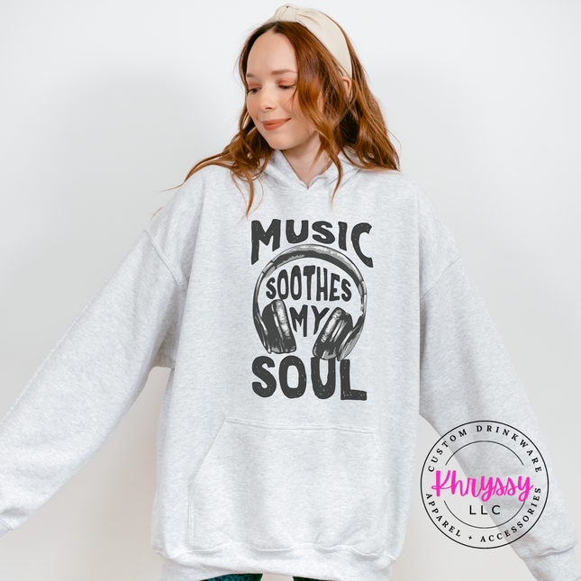 Person wearing a white hoodie with 'Music Soothes My Soul' text and headphones graphic, brand 'Physssy LLC' visible.