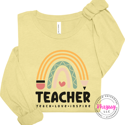 Close-up of pastel rainbow and pencil design on a french vanilla colored tee.