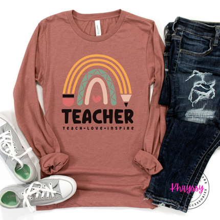 Close-up of pastel rainbow and pencil design on a Mauve colored tee.