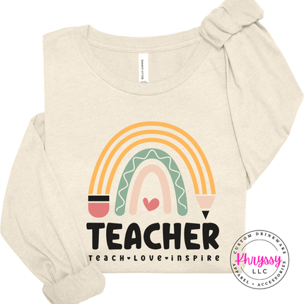 Lightweight boho rainbow teacher tee in Natural with teach love inspire text.