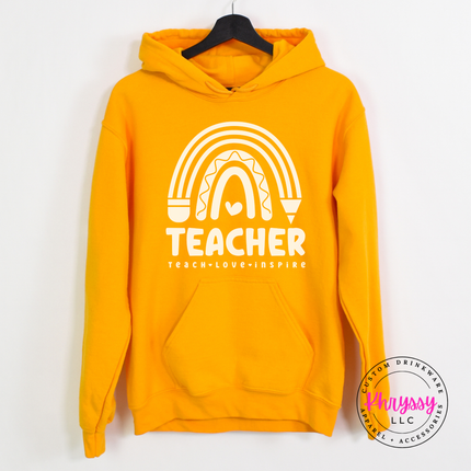 Close-up of pastel rainbow and pencil design on a Gold hoodie.
