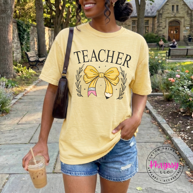 Close-up of the bow-and-pencil design and laurel leaves on a Butter tee.