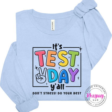 Close-up of bold multicolor test day lettering on a Baby Blue tee.