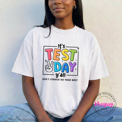 Woman wearing a White Test Day teacher tee with colorful peace sign graphic.
