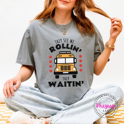 Woman wearing a Granite tee with a funny school bus driver graphic outdoors.