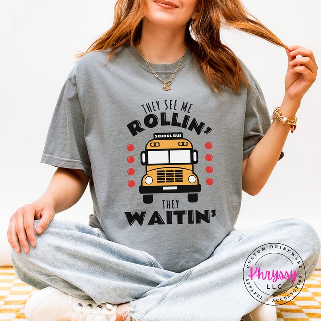 Woman wearing a Granite tee with a funny school bus driver graphic outdoors.