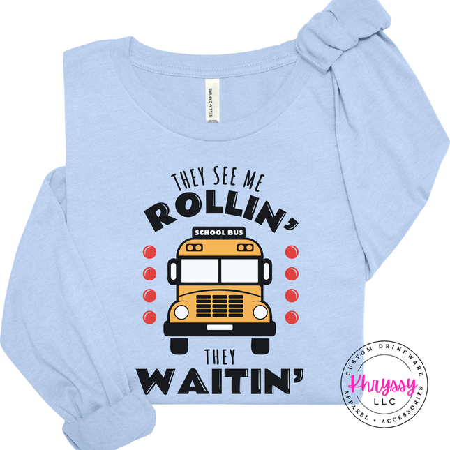 Close-up of a Baby Blue tee featuring the colorful bus print design.