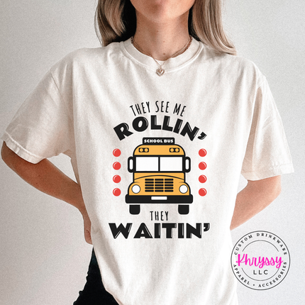 White tee styled with jeans, featuring a colorful bus graphic front print.