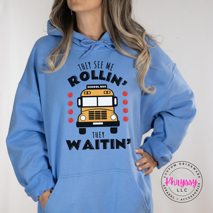 Woman wearing a Carolina Blue hoodie with a funny school bus graphic.