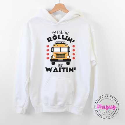 White hoodie worn outdoors, highlighting the bold yellow bus graphic