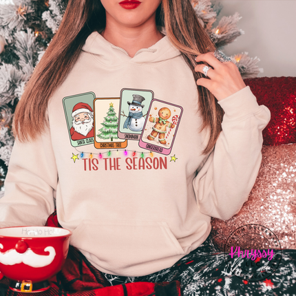 Woman wearing the Tis The Season Christmas card hoodie in Sand.