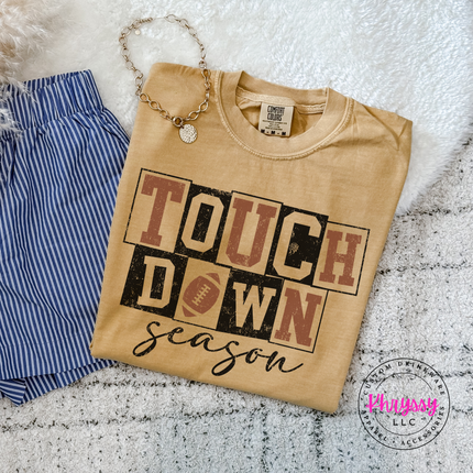 Mustard tee with a hand-illustrated touchdown season graphic print.