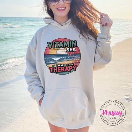 Sand hoodie featuring a faded coastal sunset and ocean wave design.