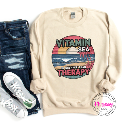 Sand crewneck featuring a faded coastal sunset and ocean wave design.