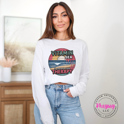 White Bella Canvas shirt with a retro Vitamin Sea beach graphic.