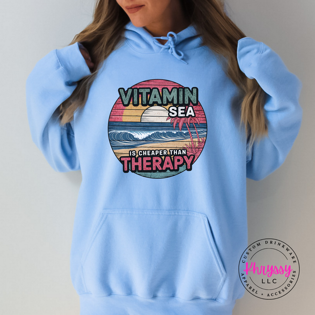 Light blue hoodie showing a distressed retro ocean beach scene.