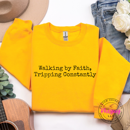 Gold crewneck sweatshirt with the tripping constantly faith humor typewriter text