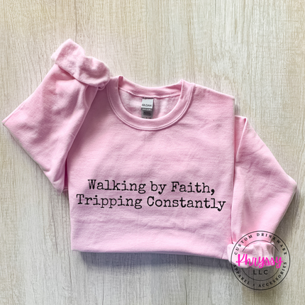 Light Pink crewneck sweatshirt with the Walking By Faith, Tripping Constantly quote