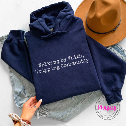 Navy hoodie with the Walking By Faith, Tripping Constantly quote