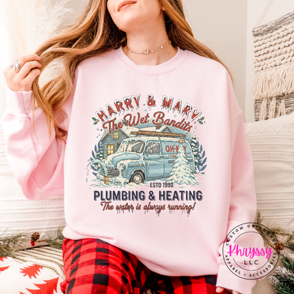 Light Pink crewneck sweatshirt with a nostalgic Christmas plumbing badge, front view.