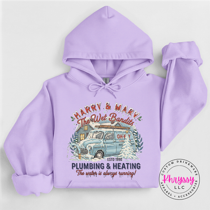 Orchid pullover hoodie showing a vintage plumbing and heating Christmas graphic, flat lay view.