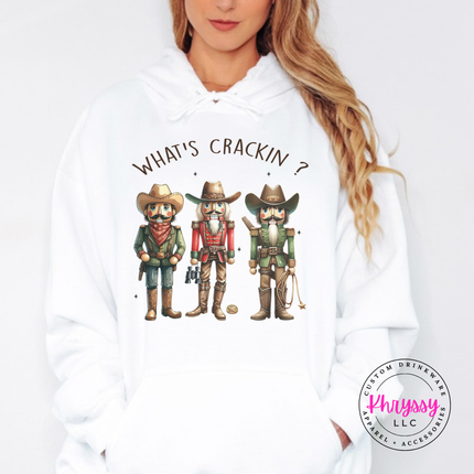 White hoodie showing cowboy nutcrackers in hats and boots.