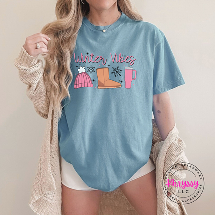 Cozy Winter Vibes beanie, boot and tumbler design on an Ice Blue tee.